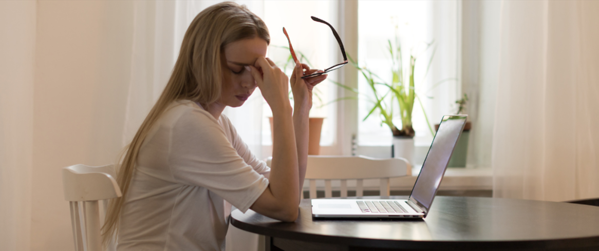 Image of a tired women sitting in front of laptop